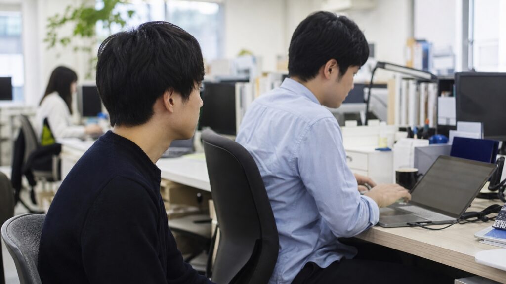 長期インターンの職場で仕事を見学する学生