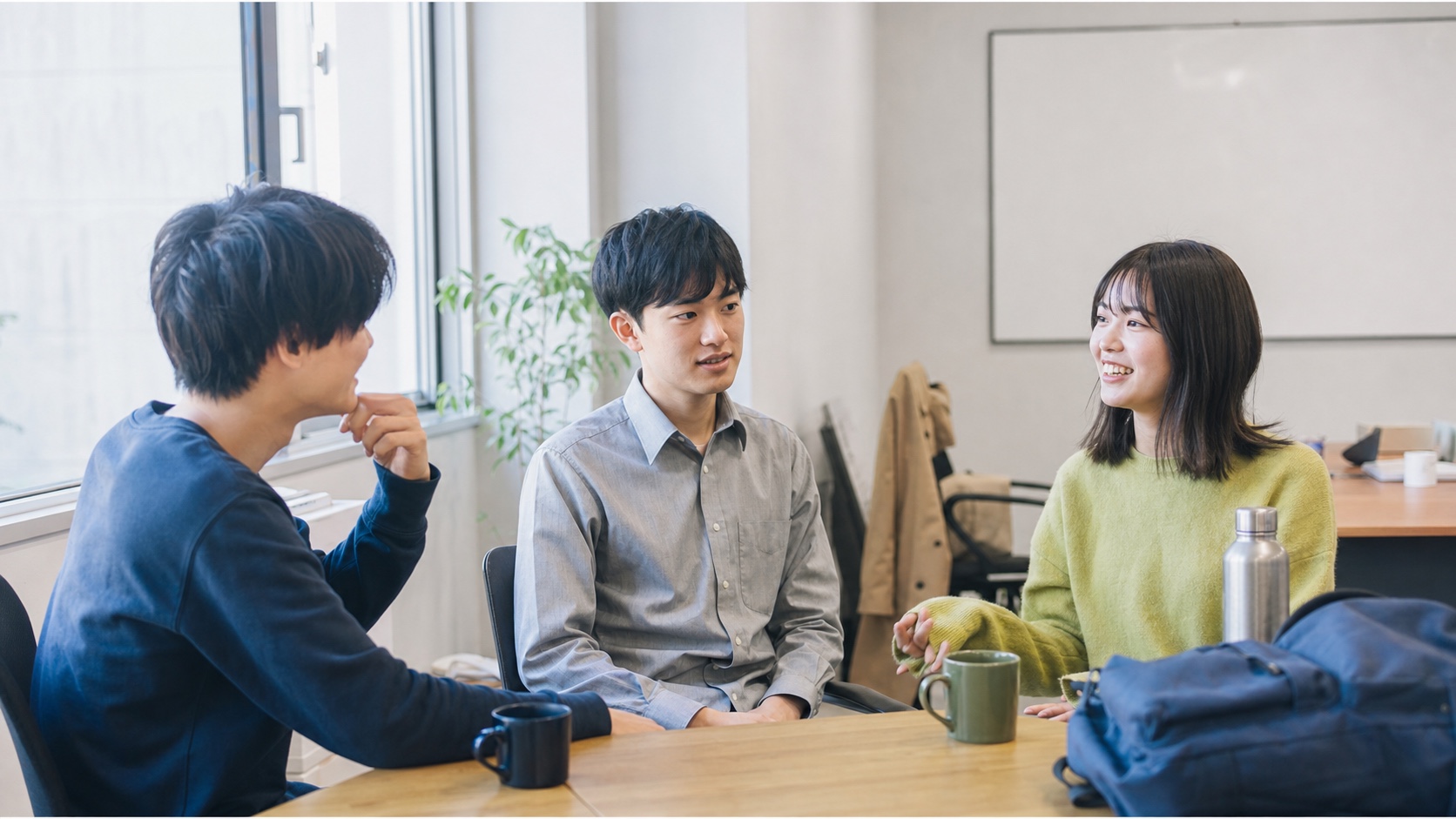 事務インターンでチームの仕事を話し合う学生